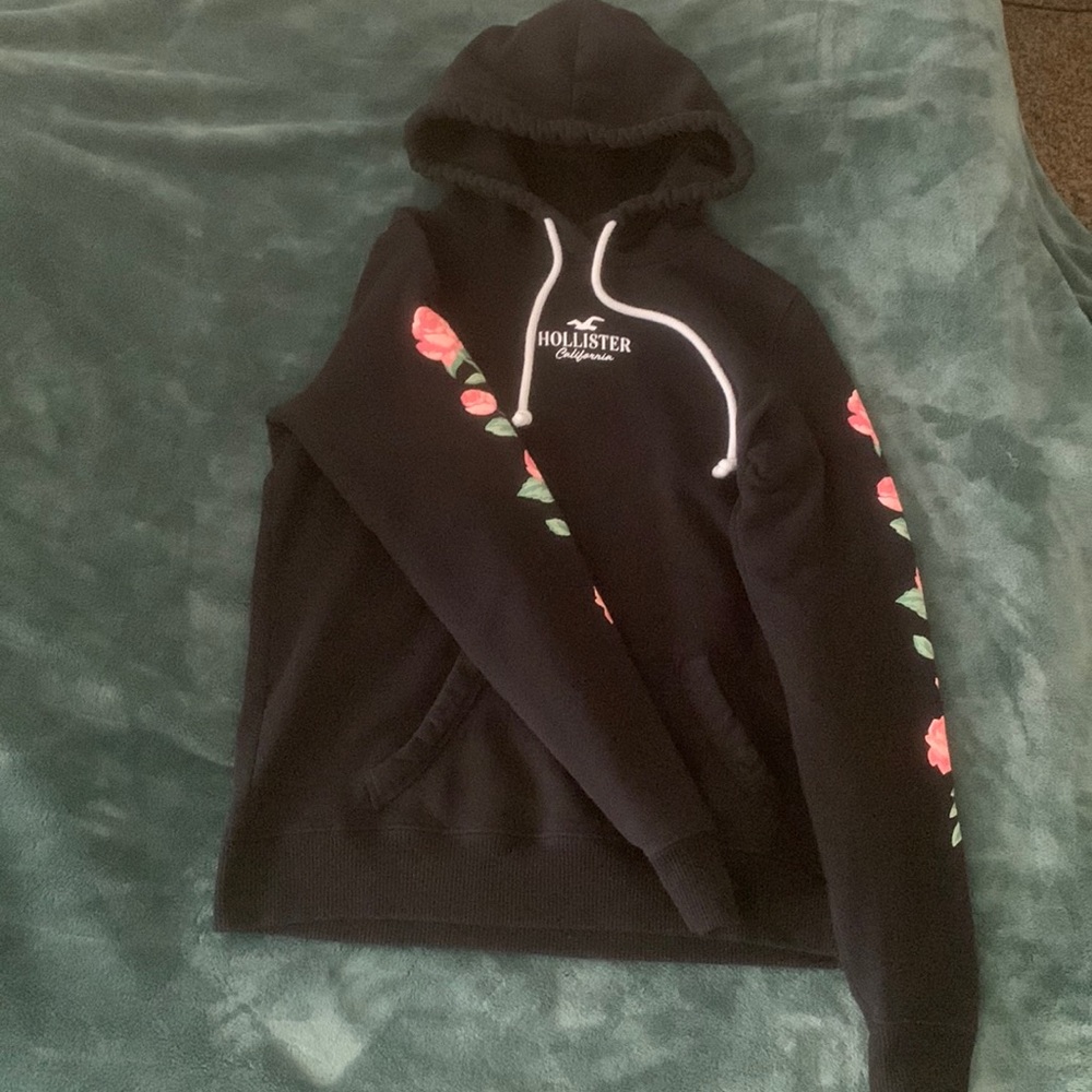 Black with flowers on sides of arms Hollister hoodie size Small.